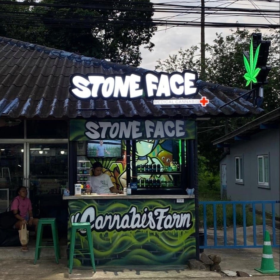 The counter at dusk with staff serving, Cannabis Farm painted across the front in graffiti script